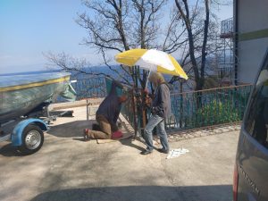 29. März 2021 - So, bald haben wir 30 Meter Geländer-Sanierung in der Villa Inge, Mošćenička Draga, geschafft. Da unser Geländer zweifarbig gestrichen wird, muss der letzte Anstrich an den Übergängen exakt sein. Hanni hilft mit einem Schirm, da die Sonne bereits stark blendet!